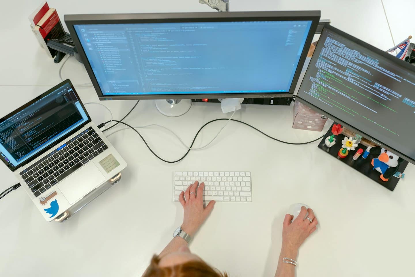 Developer coding on a multi-monitor workstation in an office.