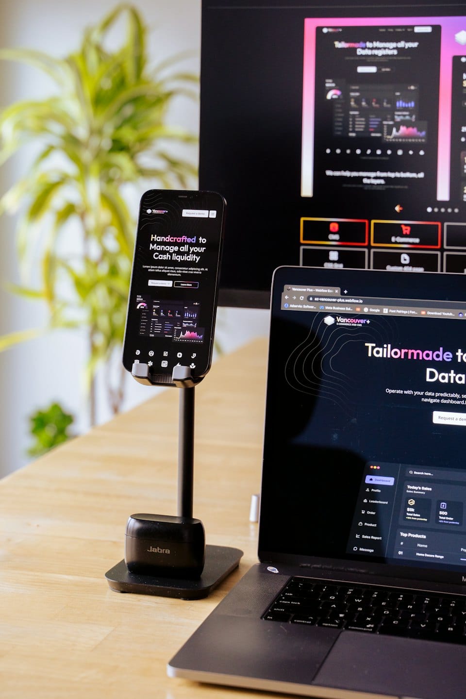 Modern office desk with laptop, smartphone, and monitor displaying business apps.